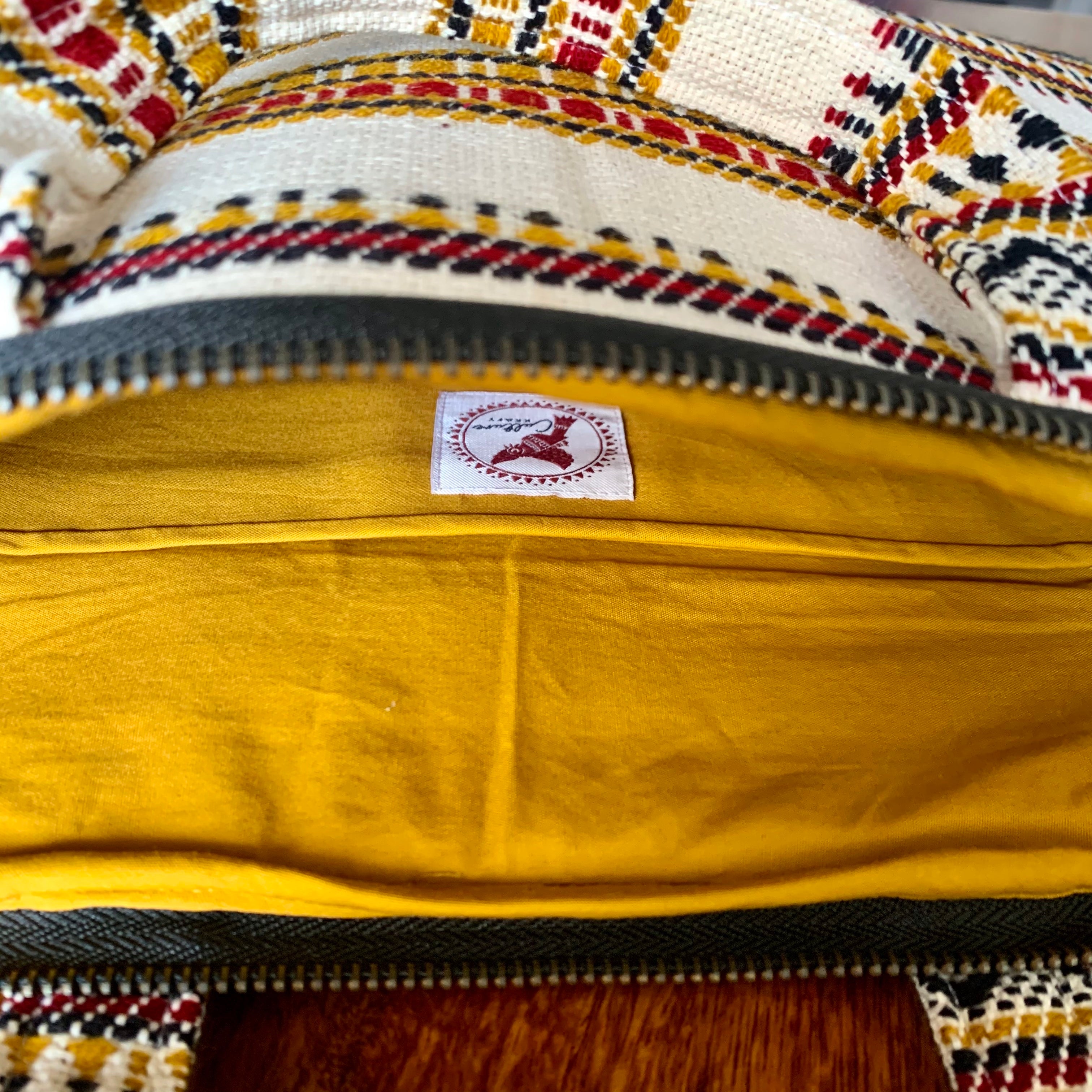 KORA Handloom Jacquard Laptop Bag featuring intricate handwoven patterns in vibrant colors, showcasing a stylish and functional design perfect for carrying laptops and essentials