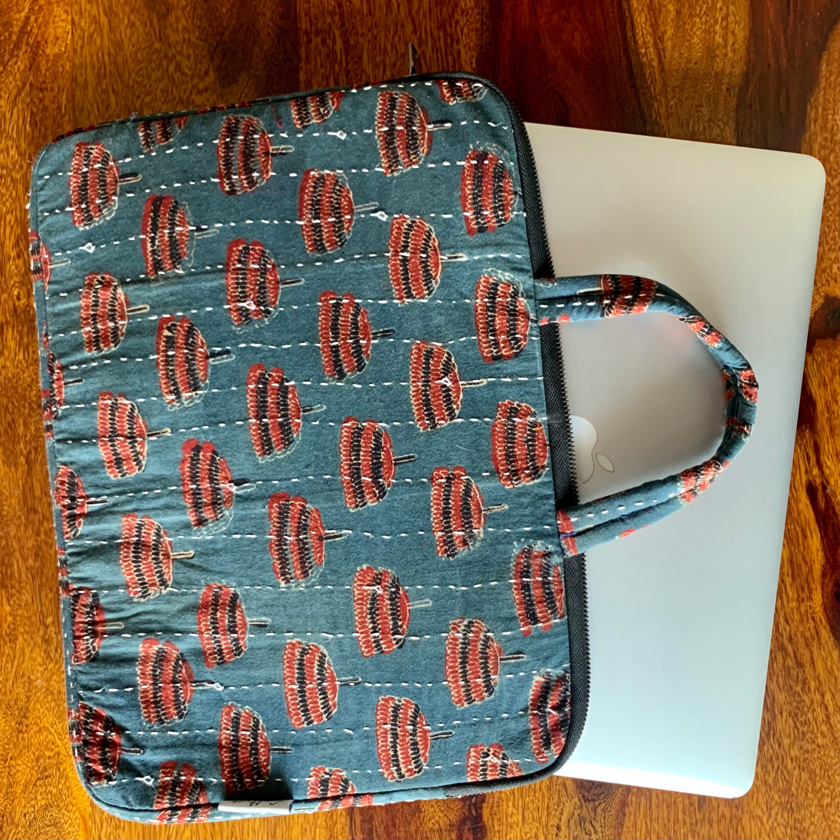 Jhumar Ajrakh handblock printed laptop bag featuring intricate traditional patterns in earthy tones, showcasing a spacious design with sturdy handles and a stylish appearance, perfect for carrying laptops and essentials.