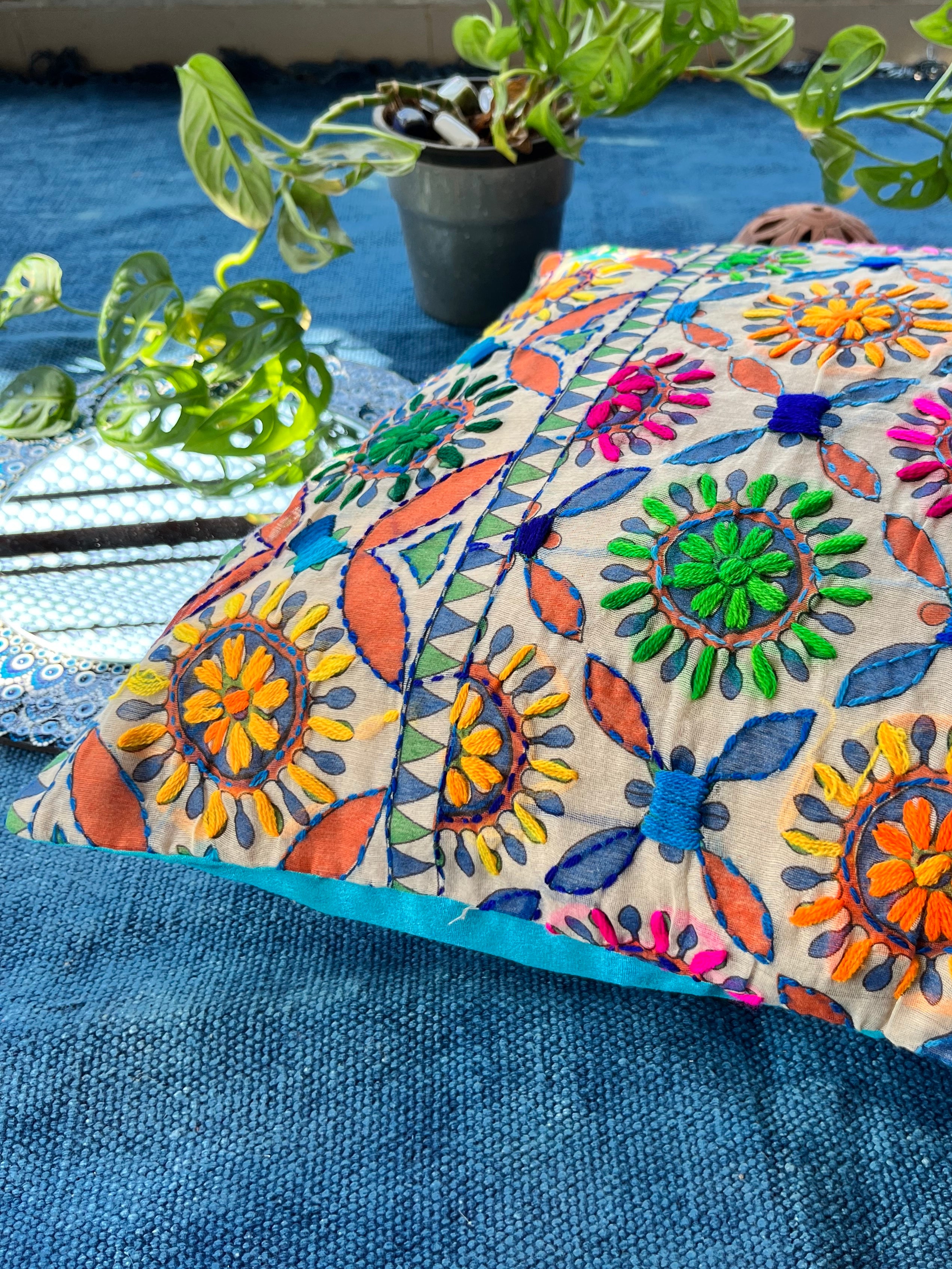 "Block printed and hand embroidered cushion cover in 18x18 size featuring intricate floral designs and vibrant colors, perfect for adding a touch of artistry to your home decor."
