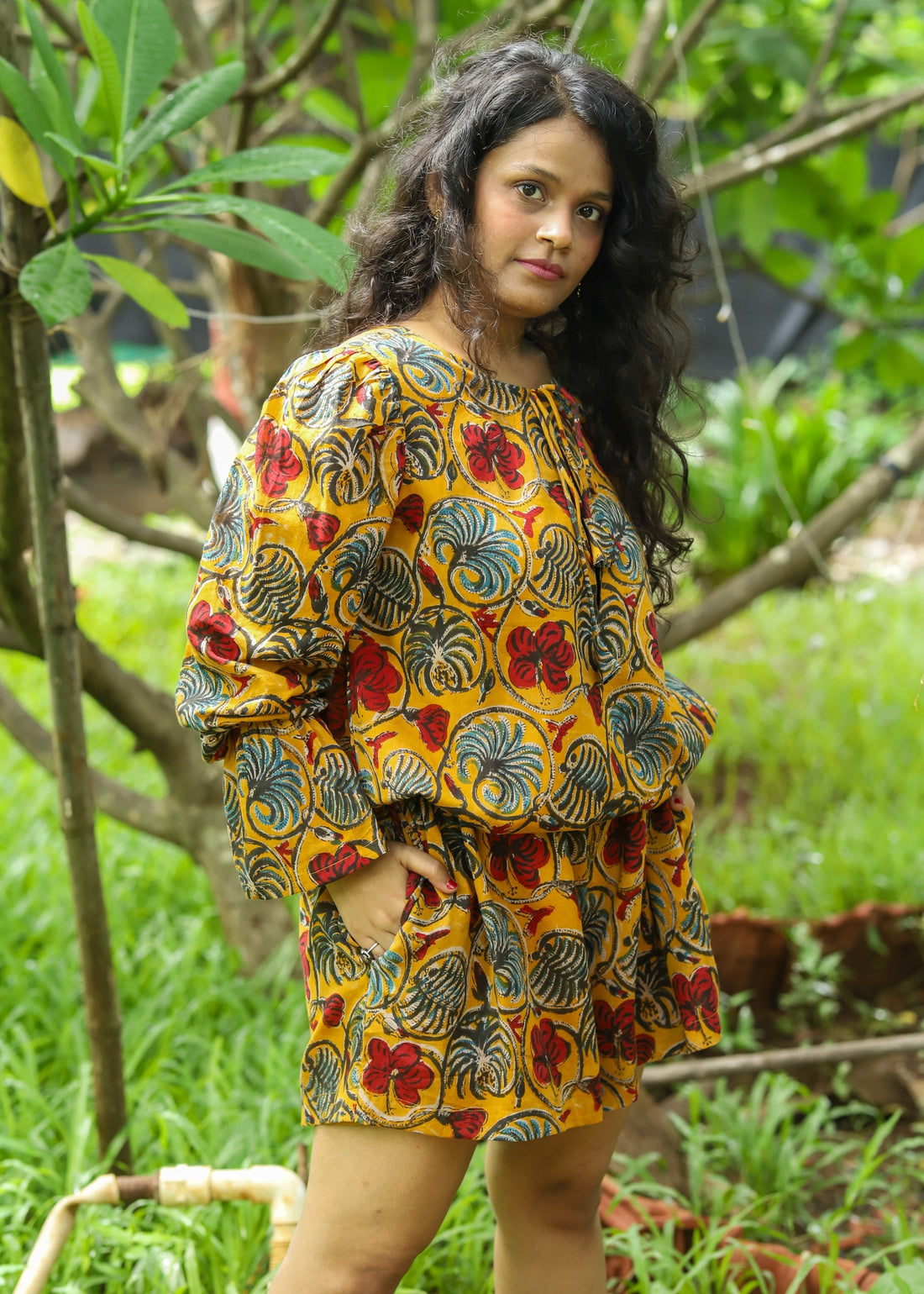 Model wearing a stylish Kyra Handblock Printed Playsuit featuring colorful floral motifs, a relaxed fit, and playful design, perfect for casual outings.