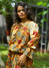 Model wearing a stylish Kyra Handblock Printed Playsuit featuring colorful floral motifs, a relaxed fit, and playful design, perfect for casual outings.