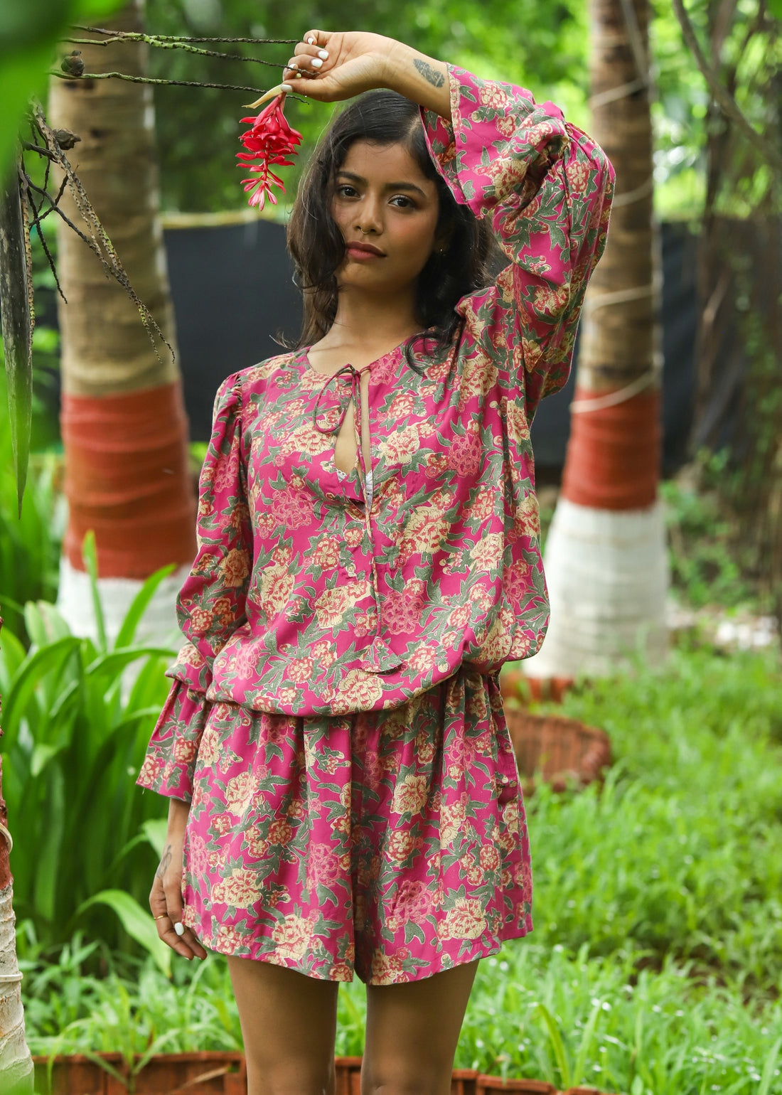 Model wearing a Faye Handblock Printed Playsuit with vibrant floral patterns, featuring a relaxed fit and short sleeves, perfect for casual summer outings.