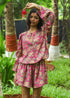 Model wearing a Faye Handblock Printed Playsuit with vibrant floral patterns, featuring a relaxed fit and short sleeves, perfect for casual summer outings.