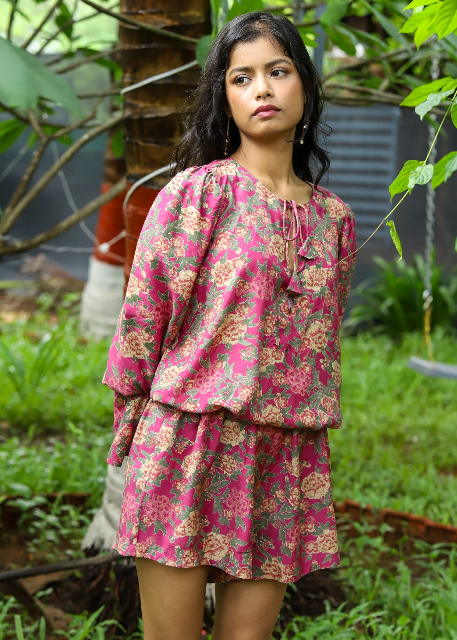 Model wearing a Faye Handblock Printed Playsuit with vibrant floral patterns, featuring a relaxed fit and short sleeves, perfect for casual summer outings.