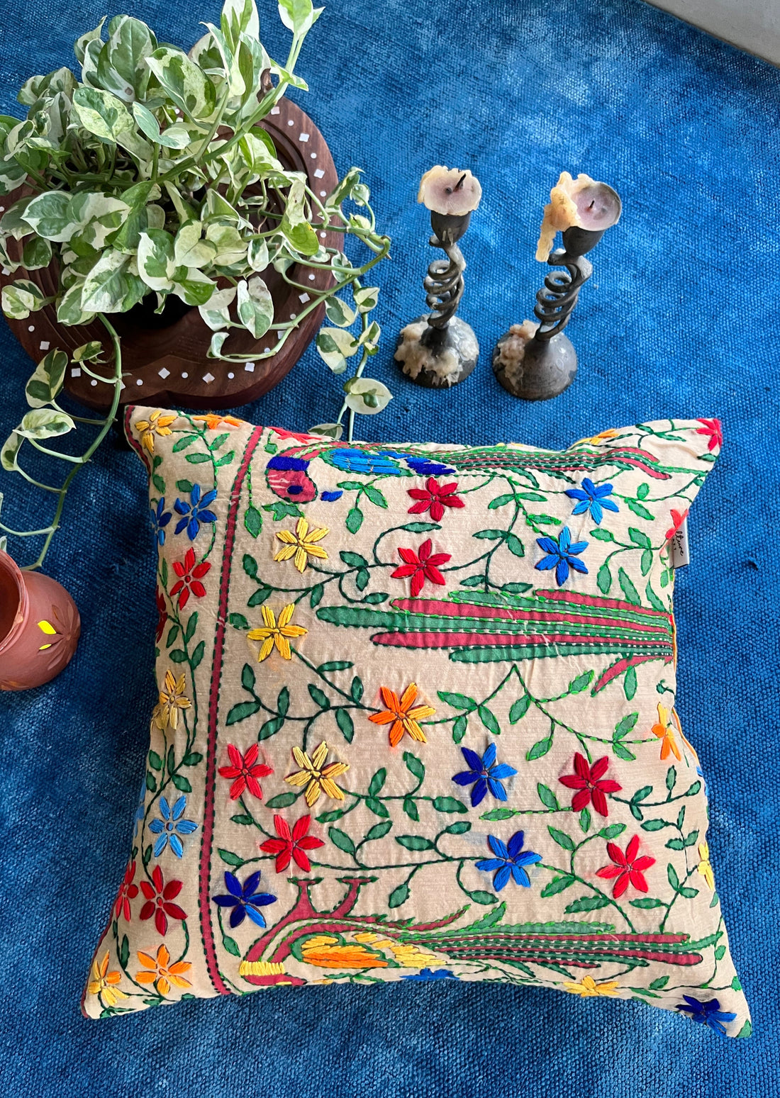 "16x16 inch cushion cover featuring vibrant block printed patterns and intricate hand embroidery, adding a touch of artisanal charm to any space."
